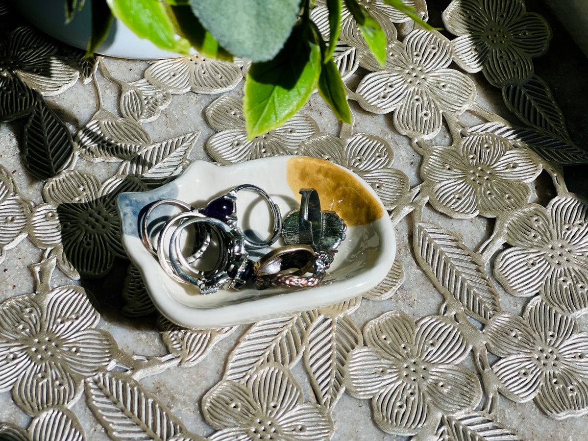 Silver rings on a textured stone surface with floral patterns