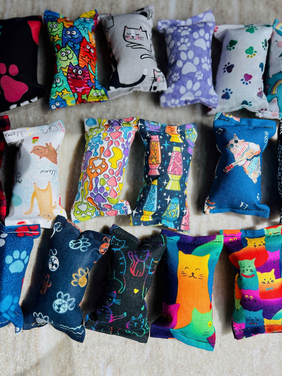 Colorful catnip toys with various patterns on a textured surface