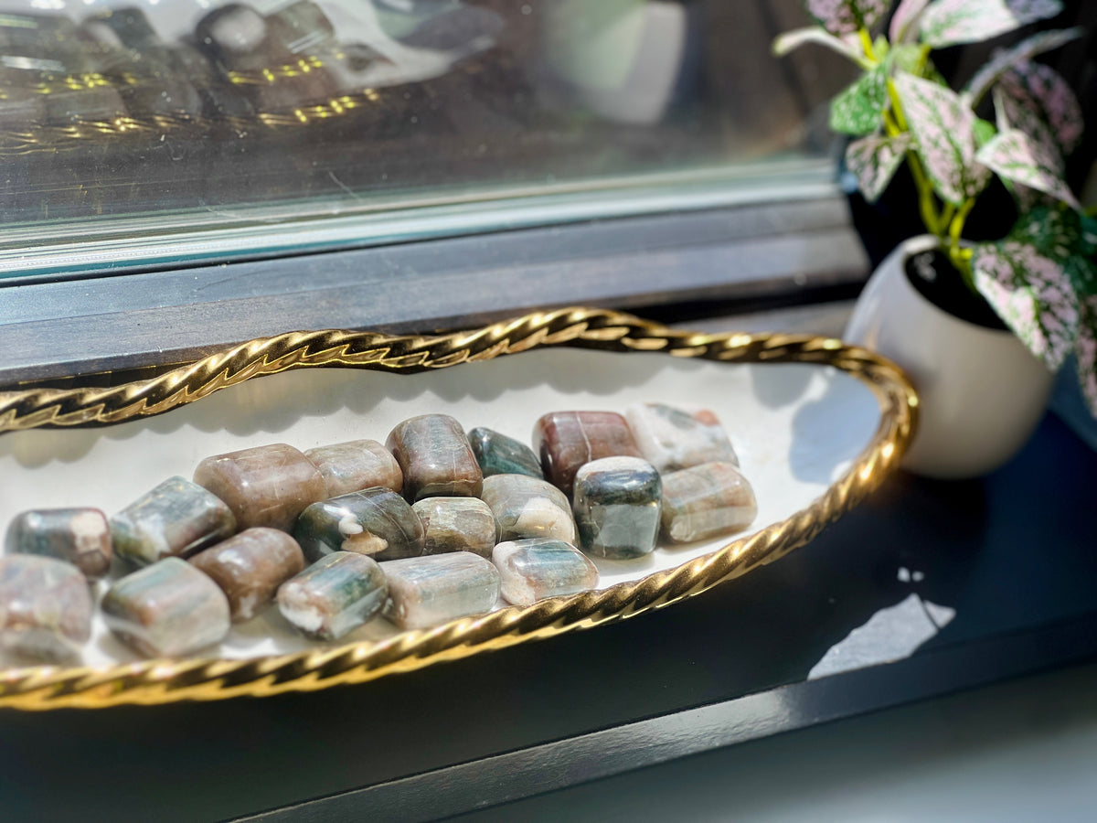 Decorative tray with stones on a reflective surface