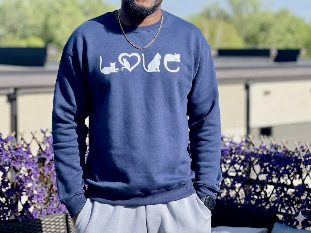 Person wearing a navy blue sweatshirt with white LOVE graphics outdoors