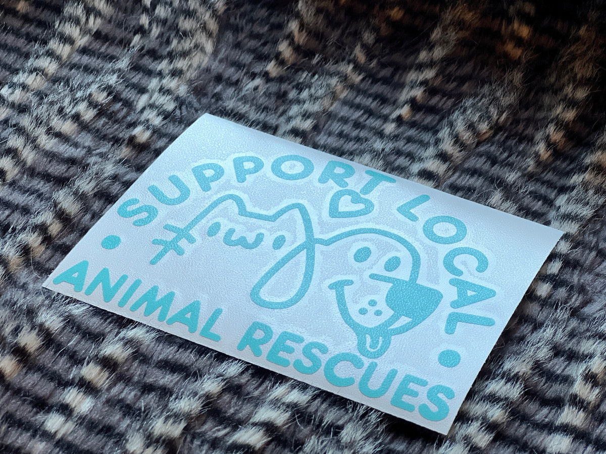Light Blue sticker with 'Support Local Animal Rescues' text on a textured fabric background
